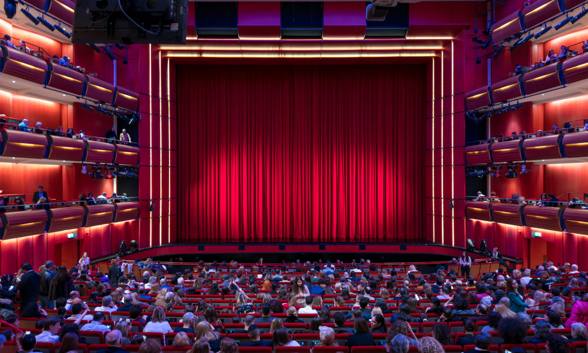 audience facing a theatre stage before a show begins